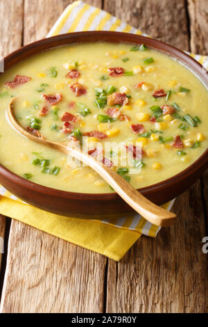 Traditionelle Hot corn Chowder mit Speck und grüne Zwiebeln close-up in einem Teller auf dem Tisch. Vertikale Stockfoto