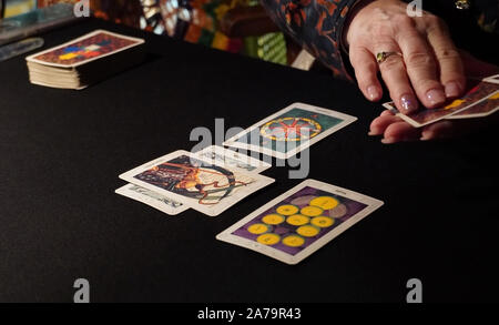 Boothbay Harbor, ME/USA - Oktober 20, 2019: Tarot card reader Ordnet die Karten in einem 6-Karte verteilt Stockfoto