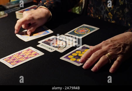 Boothbay Harbor, ME/USA - Oktober 20, 2019: Tarot card reader Ordnet die Karten in einem 6-Karte verteilt Stockfoto