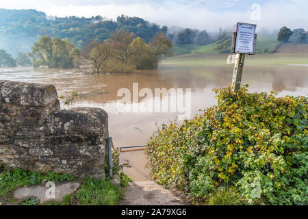 Das Wye Valley zu Fuß langen Fußweg unterhalb der schlammigen, sandiges Wasser des Flusses Wye in der Flut am 28.10.2019 bei Kerne Brücke, Hereford versenkt Stockfoto