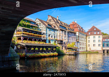 Typische Fachwerkhäuser säumen den Fluss Ill in der Petite France Viertels in Straßburg, Frankreich, unter dem Saint-Martin Brücke gesehen. Stockfoto