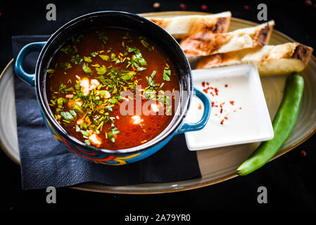 Traditionelle türkische Suppe aus Rumänien mit frischem Gemüse, Wischcreme, Gewürzen und hausgemachtem Brot Stockfoto