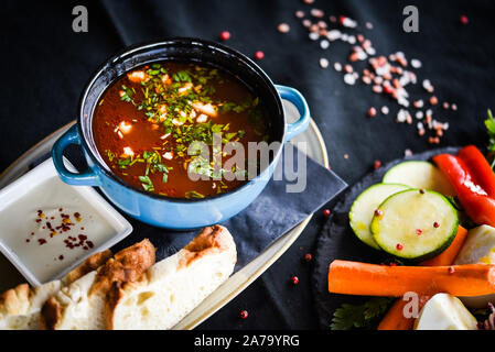 Traditionelle türkische Suppe aus Rumänien mit frischem Gemüse, Wischcreme, Gewürzen und hausgemachtem Brot Stockfoto
