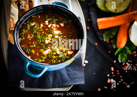 Traditionelle türkische Suppe aus Rumänien mit frischem Gemüse, Wischcreme, Gewürzen und hausgemachtem Brot Stockfoto