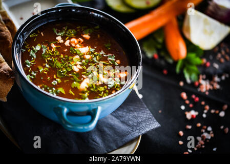 Traditionelle türkische Suppe aus Rumänien mit frischem Gemüse, Wischcreme, Gewürzen und hausgemachtem Brot Stockfoto
