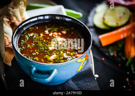 Traditionelle türkische Suppe aus Rumänien mit frischem Gemüse, Wischcreme, Gewürzen und hausgemachtem Brot Stockfoto