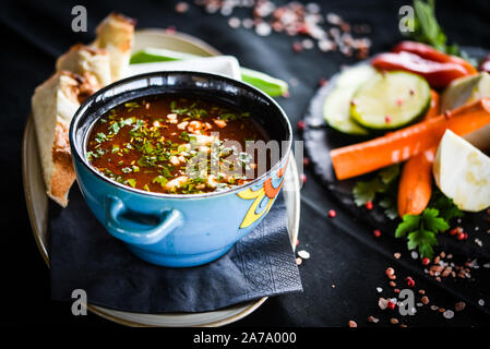 Traditionelle türkische Suppe aus Rumänien mit frischem Gemüse, Wischcreme, Gewürzen und hausgemachtem Brot Stockfoto