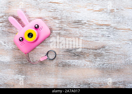 Pink Kamera mit lustigen Ohren und eine Tasse auf einem hellen Hintergrund Stockfoto