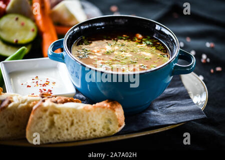 Traditionelle türkische Suppe aus Rumänien mit frischem Gemüse, Wischcreme, Gewürzen und hausgemachtem Brot Stockfoto