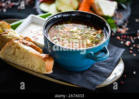 Traditionelle türkische Suppe aus Rumänien mit frischem Gemüse, Wischcreme, Gewürzen und hausgemachtem Brot Stockfoto