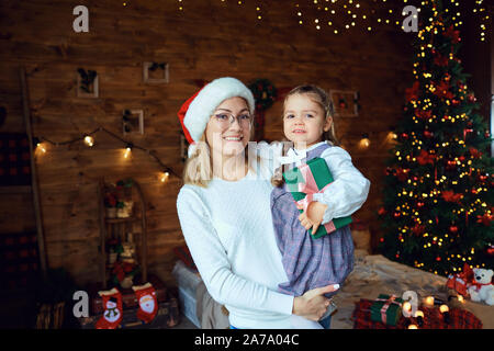 Mutter mit ihrer Tochter mit Geschenken zu Weihnachten. Stockfoto