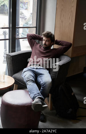 Hübscher junger Geschäftsmann ruht im Cafe. Attraktive bärtiger Mann am Tisch ist in der Cafeteria sitzen und Träumen. Stockfoto