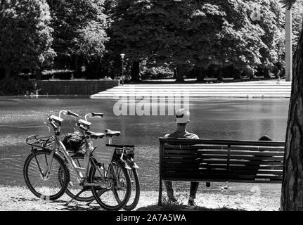 Paar auf einer Bank Ausruhen nach einer langen Radtour auf einem gemieteten Fahrrad in Malmö, Schweden Stockfoto