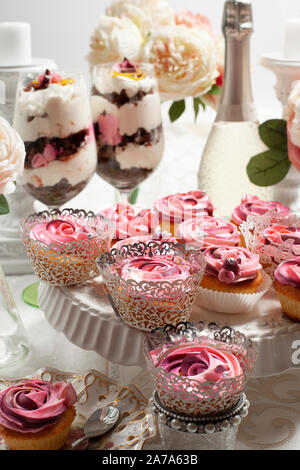 Eine schöne Zusammenstellung von Pink und rosa Schale Kuchen auf einem luxuriösen Tabelle einstellen Stockfoto