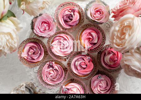 Eine schöne Zusammenstellung von Pink und rosa Schale Kuchen auf einem luxuriösen Tabelle einstellen Stockfoto