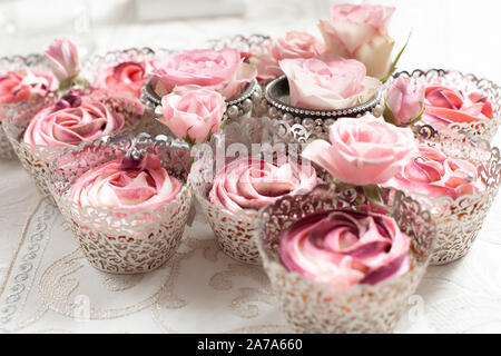Eine schöne Zusammenstellung von Pink und rosa Schale Kuchen auf einem luxuriösen Tabelle einstellen Stockfoto