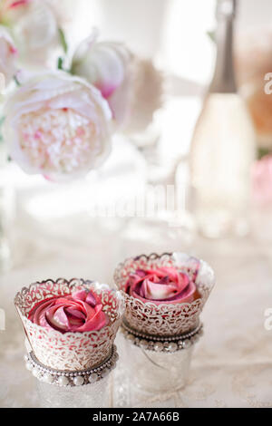 Eine schöne Zusammenstellung von Pink und rosa Schale Kuchen auf einem luxuriösen Tabelle einstellen Stockfoto