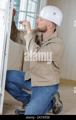 Man verwendet einen Schraubendreher, ein Glas Tür einstellen Stockfoto