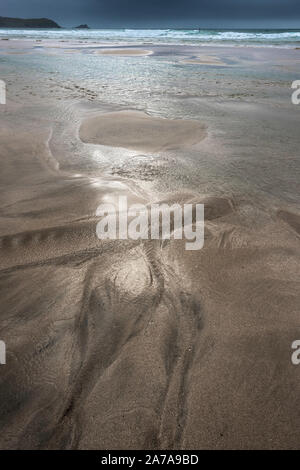 Eine dunkle Spuren im Sand, die von einem rückläufigen Flut auf den Fistral Beach in Newquay in Cornwall. Stockfoto