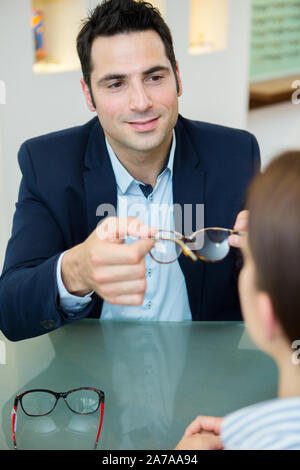 Männliche Arbeiter verkaufen Brillen Optik store Stockfoto