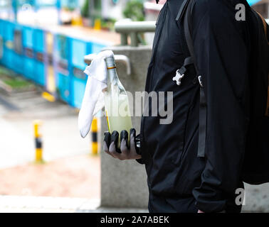 13. Okt 2019. Pro-demokratischen Demonstranten auf der Straße in Tai Po in Schwarz bei einem Mob Protest durch das Gebiet gekleidet. Dargestellt in der vergangenen Nacht einen sogenannten Molotow - Cocktail Stockfoto