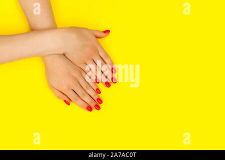 Schöne Frau Maniküre am trendigen gelben Hintergrund. Minimalistische Maniküre Trend. Ansicht von oben, flach. Kopieren Sie Platz für Text. Stockfoto
