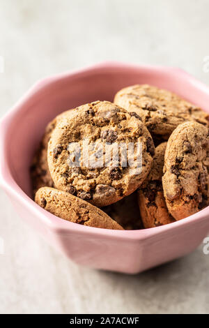 Kekse und ähnliches Kleingebäck, gesüßt. Cookies Schokolade in rosa Schüssel. Stockfoto