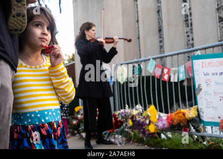 Pittsburgh, USA. 27 Okt, 2019. Ein Mädchen sieht neben einer Frau spielt eine Violine am Denkmal. Ein Jahr nach der Schießerei am Baum des Lebens Synagoge in Squirrel Hill, Pittsburgh, PA, viele zurück in die Schule, um ihren Respekt zu bezahlen. Credit: Aaron Jackendoff/SOPA Images/ZUMA Draht/Alamy leben Nachrichten Stockfoto