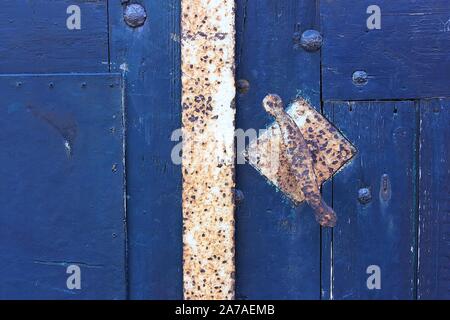 In der Nähe von Alte blaue Tür mit rostigem Eisen Türgriff Stockfoto