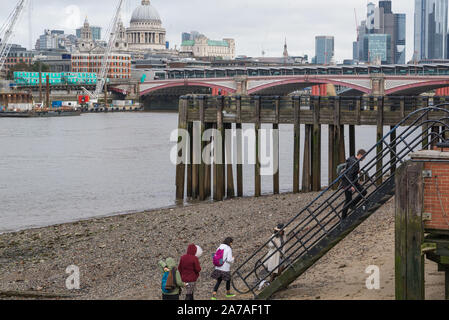 Gruppe von Menschen die Treppen von der Themse vorland an Oxo Tower Wharf, London, England, UK. Der Londoner City und St. Paul's im Hintergrund. Stockfoto