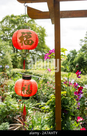 Zwei rote Laternen in einem Englischen Garten im chinesischen Stil in Wiltshire England Großbritannien entwickelt wurde Stockfoto