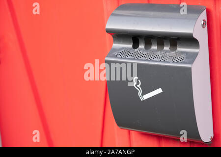Zigarettenraucher stahl Metall Aschenbecher eingebaut, rote Wand Stockfoto