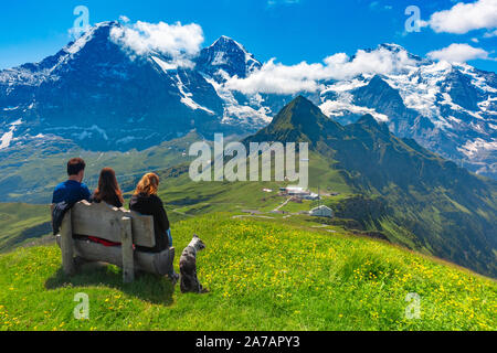 Touristen bewundern Eiger, Mönch und Jungfrau vom Gipfel des Berges Mannlichen, beliebter Aussichtspunkt in den Schweizer Alpen, Schweiz. Stockfoto