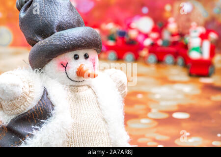Nahaufnahme der Schneemann im Vordergrund, Weihnachtszeit Hintergrund mit Dekorationen. Frohe Weihnachten neues Jahr Sammlung, Geschenke und dekorative orn Stockfoto