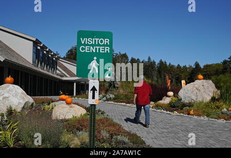 Boothbay, ME/USA - Oktober 19, 2019: Mann geht zum Küstenmaine botanischen Gärten Besucherzentrum (Fokus auf Zeichen) Stockfoto