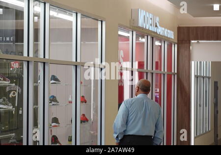 Alexandria, VA/USA - 24. September 2019: im mittleren Alter kaukasischer Mann starrt auf den Schuh Anzeige durch ein Fenster in der Mall Stockfoto