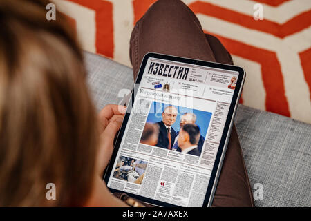 Paris, Frankreich - Jun 2, 2019: Frau liest auf Neuigkeiten von Apple App auf dem Ipad Tablet die elektronische Version der russischen Zeitung "Iswestija" mit Putin und Investitionsklima auf dem Deckblatt Stockfoto