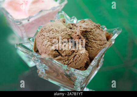 Schokolade Eis in ein Glas Vase. Auf dem Tisch ist eine Glasschale mit einer Portion Eis. Köstliche Schokolade Dessert in einem Sommer Cafe. Stockfoto
