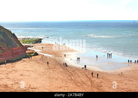 Einen schönen sonnigen Morgen Mitte September und die Menschen nutzen die Ebbe zu Fuß rund um die sandsteinfelsen am Ende von Exmouth Beach. Stockfoto