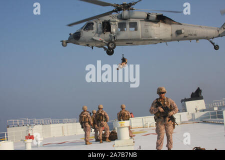 Gerade von HORMUZ (24.10.2019) Marines zugeordnet Flotte Anti-terror-Security Team, Central Command (FASTCENT) vorbereiten, indem ein Navy MH-60S Seahawk, angeschlossen an Hubschrauber Meer Combat Squadron 26 (HSC-26) von der Arc Liberty, eine militärische Sealift Command Zeit gecharterte Schiff extrahiert werden, nachdem die Sicherheit während einer Straße von Hormuz Transit. FASTCENT Marines arbeiten mit US-Partnern und Verbündeten zu Personal und Eigentum zu schützen und gleichzeitig die Freiheit der Schifffahrt in internationalen Gewässern. Task Force 51 und 5. Marine Expeditionary Brigade ist mit schnell agg übertragen Stockfoto