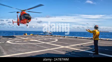 Einem MH-65 Dolphin Hubschrauber Besatzung Hubschrauber Verbot taktische Squadron (HITRON) landet auf dem Flugdeck der Coast Guard Cutter James zugewiesen, während die Durchführung von Hurrikan Hilfsmaßnahmen in der Karibik, Sept. 6, 2019. Während ihrer 62-tägigen Drogenbekämpfung Patrouille, die James' Crew, zusammen mit Mitgliedern aus taktischen Strafverfolgung Team-South, HITRON, Cryptologic direkte Unterstützung Element und mehrere Partner Agenturen trugen dazu bei, das Verbot von 7 Droge - schmuggel Schiffe und Waren verantwortlich für die Ergreifung von mehr als 12,677 Pfund Kokain und 4,085 lbs Marihuana gebunden f Stockfoto