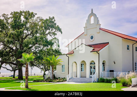 Live Oak Bäumen und Palmen stehen vor einem spanischen Kolonialstil Kapelle an der hundertjährigen Plaza, Okt. 22, 2019 in Gulfport, Mississippi. Stockfoto