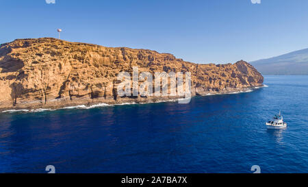 Molokini Krater, Luftaufnahme von der Rückwand des sichelförmigen Insel mit einem Tauchgang Charter Boot nähert, Maui, Hawaii. Stockfoto