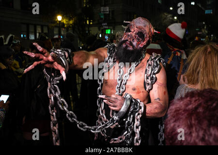 New York, NY - 31. Oktober 2019. Die jährliche Greenwich Village Halloween Parade entlang Manhattans 6. Avenue. Eine verkettete und gefesselten Mann mit einem blutigen Maske und einen Nagel durch den Kopf. Credit: Ed Lefkowicz/Alamy leben Nachrichten Stockfoto