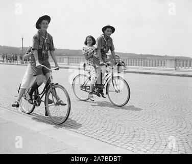 Zwei Pfadfinder geben ihre Freundinnen eine Fahrt mit dem Fahrrad über den Arlington Bridge CA. 1937 Stockfoto