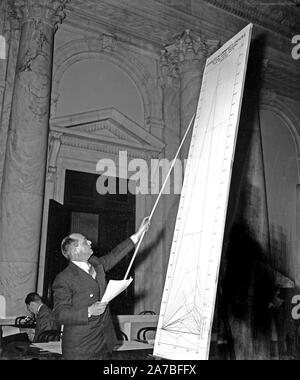 Mann in kongreßhörfähigkeit, der auf eine Linie auf einem sehr großen Diagramm kann. 1939 Stockfoto