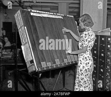 Soziale Sicherheit Geschichte - ein Arbeiter in der Sozialen Sicherheit Bord Aufzeichnungen Büro bei der Arbeit an der "sichtbare" Rack Ca. 1937 oder 1938 Stockfoto