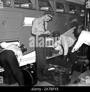 Arbeitnehmer bei der Greyhound Bus Station laden und prüfen Gepäck Ca. 1937 Stockfoto
