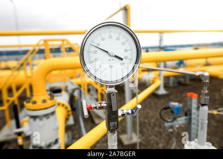 Industrielle Ausrüstung (Rohre, Manometer-/Druckmesser, Hebel, Armaturen, Indikatoren) in einer natürlichen Gasverdichterstation. Stockfoto