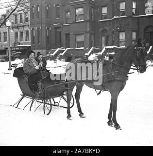 Socialites genießen Sie den Winter. Diese zwei prominente Mitglieder der sozialen Washingtons geniessen Sie die klare, kalte Nachwirkungen der Blizzard, die die Straßen links mit fast ein Fuß Schnee bedeckt. Miss Evelyn Walker, Tochter von Herrn und Frau Harold Walker, trägt die Russisch-Typ hat. Ihr Begleiter ist Frau Eppes Hawes Preston, Tochter des ehemaligen Senator und Frau Harry B. Hawes Stockfoto